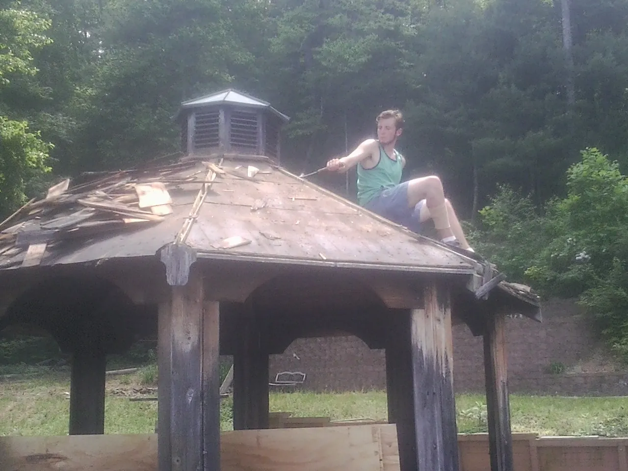 Tearing the old roof off a wooden gazebo before new shakes in Lakeview